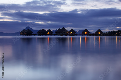 view of bungalows at sea on sunset background 