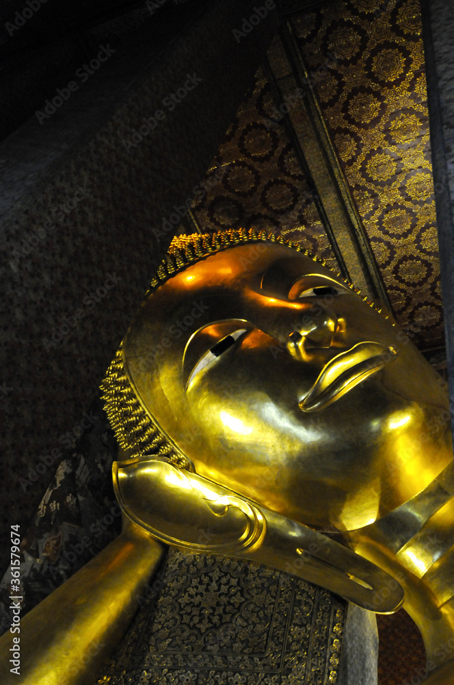 Gros Plan sur le visage doré du plus grand Bouddha couché de Thaïlande à Bangkok.