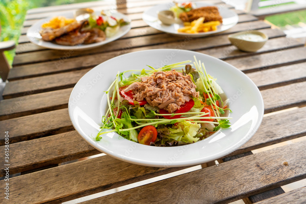 Restaurant serving food. Tuna salad in a plate on a table in a summer cafe Restaurant serving food. Tuna salad in a plate on a table in a summer cafe