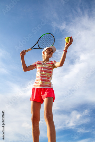 Young tennis girl is getting ready to serve. Professional sport.