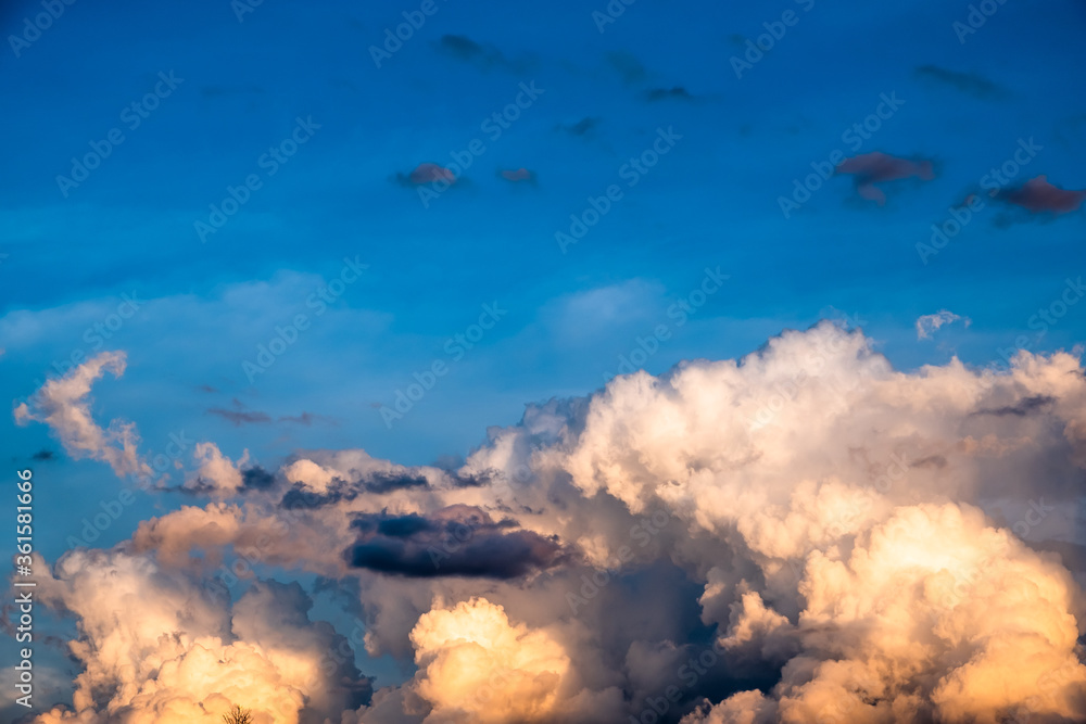 Background of clear blue sky on the upper part and dramatic cumulonimbus clouds on the lower part with rays of light. Clouds in the sky.
