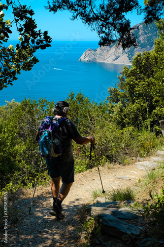 Persona adula sul sentiero azzurro delle cinque terre, monte rosso sul mare. concetto di vacanze in Liguria