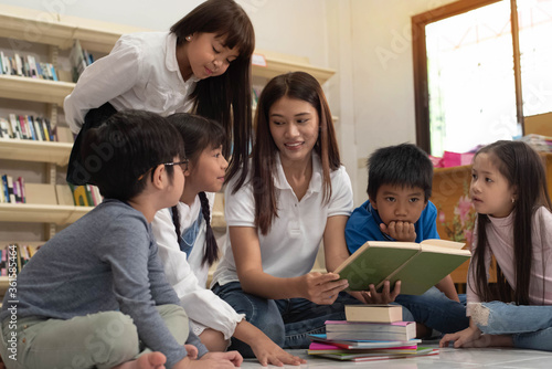 The beautiful lady reading book with little children with happy feeling,blurry light around