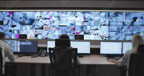 Slow motion footage of security control room operator at work, Security System Operator Looking At Cctv Footage photo