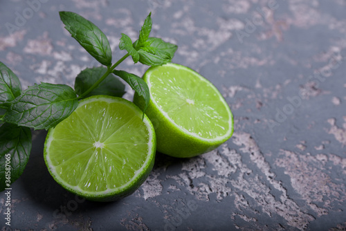 Lime and mint leaves on the gray background.