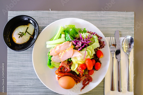 salad hot dog sushi in white plate and spoon with khife on the table photo