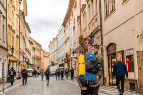 A tourist with a large backpack is walking along the street of old Europe.