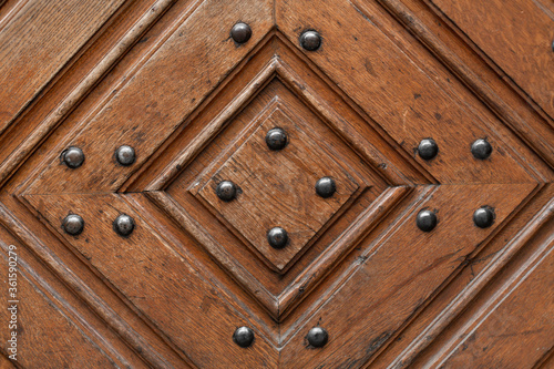 Texture of a wooden door with metal rivets. Wood diamond pattern