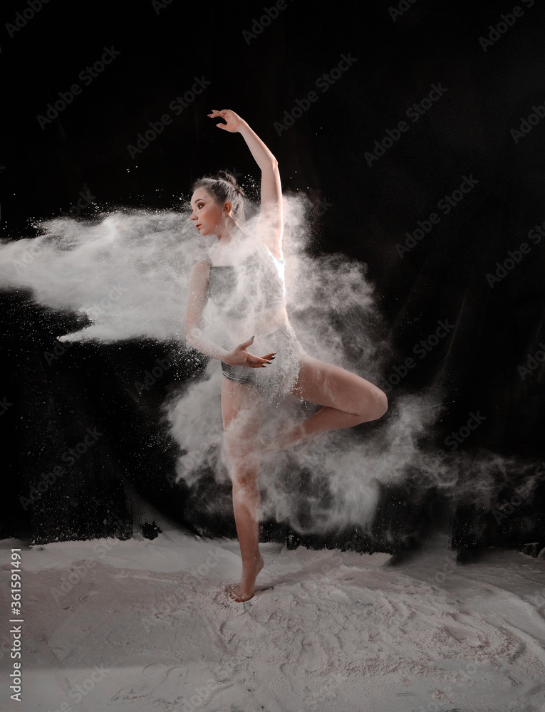 Girl dansing with flour on black background one person
