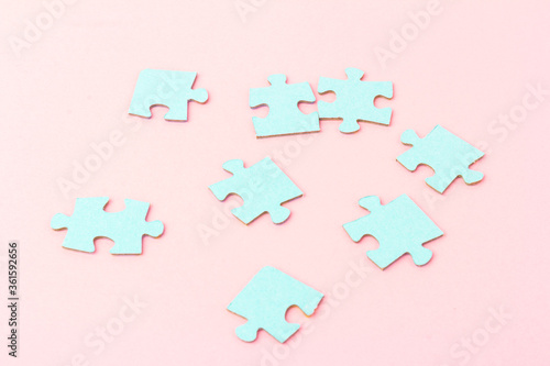 Blue puzzle pieces with empty space for your text and design on pink background.