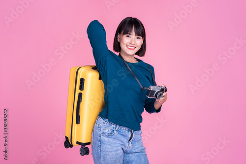 Traveling and tourism, Asian cute girl holding backpack suitcase and camera, on journey travel exploration adventure visit holiday vacation packing luggage on pink isolated background copy space