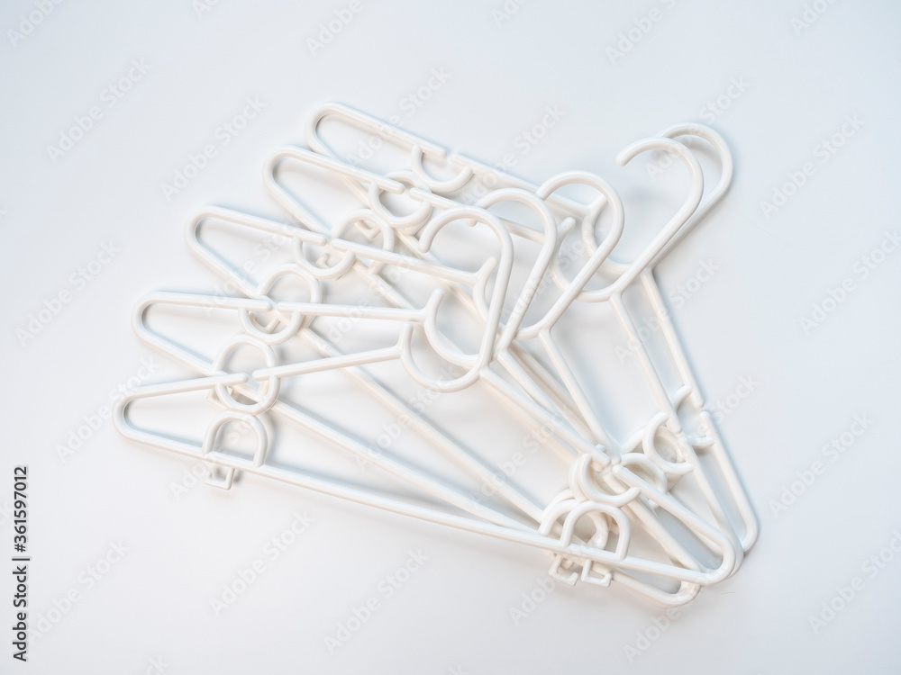 Fototapeta premium Pattern of white plastic hanger on white and pastel background color. Copy space provided.