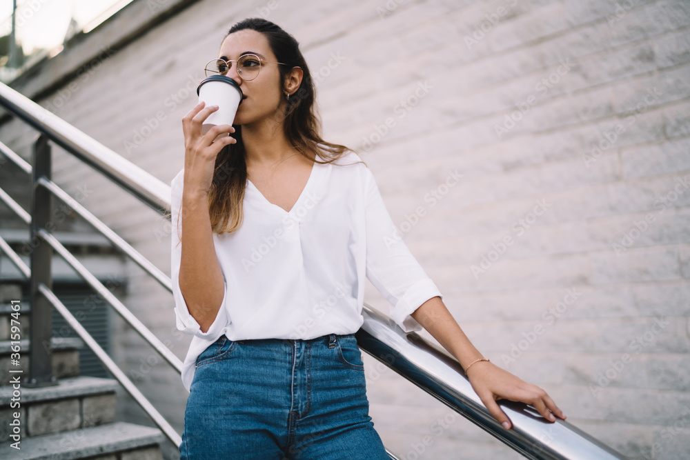 Brooding woman standing with cup of coffee