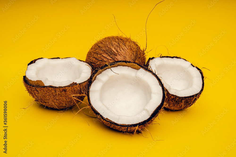 Parts of coconut on a colored background. Close up. Fresh ripe coconut broken into pieces. Parts of coconut on a colored background. Close up. Fresh ripe coconut broken into pieces.