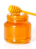 golden bee honey in a glass jar and honey dipper