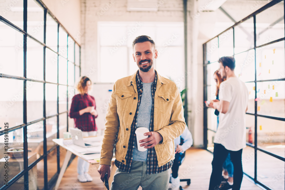 Half-length portrait of cheerful matured manager dressed in casual outfit having work break in office, successful coach of designers team satisfied with career and productive job with colleagues