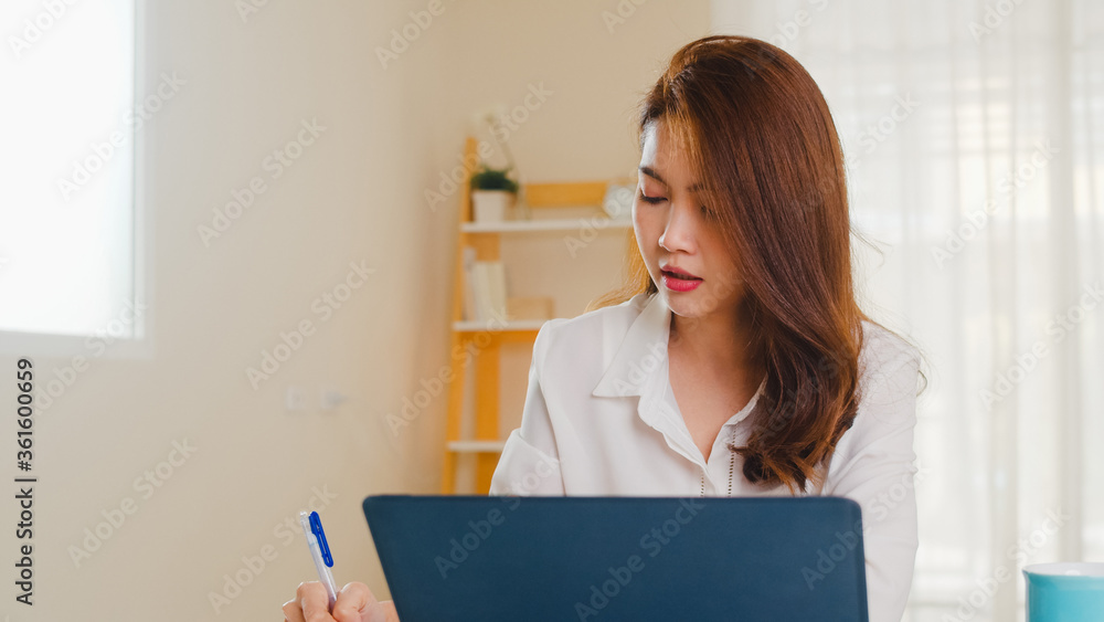 Portrait of freelance Asia women casual wear using laptop working in living room at home. Working from home, remotely work, self isolation, social distancing, quarantine for coronavirus prevention. Portrait of freelance Asia women casual wear using laptop working in living room at home. Working from home, remotely work, self isolation, social distancing, quarantine for coronavirus prevention.