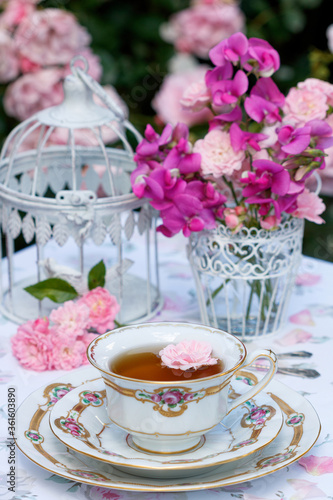 vintage Tischdekoration mit Teetasse, Blumenstrauss und Vogelkäfig