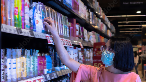 woman wearing a protective mask do grocery after open lockdown in supermarket, to protect and spread out of virus. new normal concept