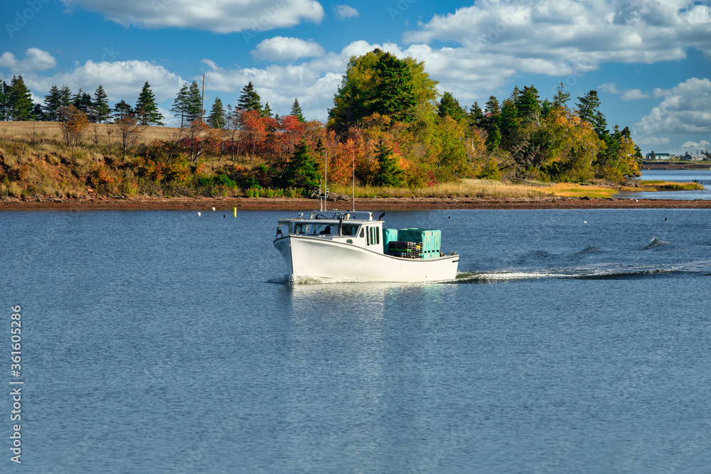 Obraz premium Lobster fishing boat sailing into port in rural Prince Edward Island, Canada.