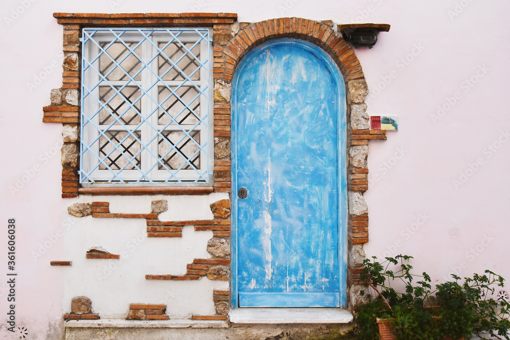 Detail of an old house with blue wooden door and white window - Facade ...
