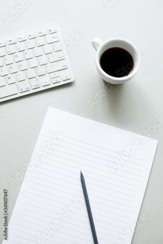 Blank paper for notes, cup of coffee and keyboard. 