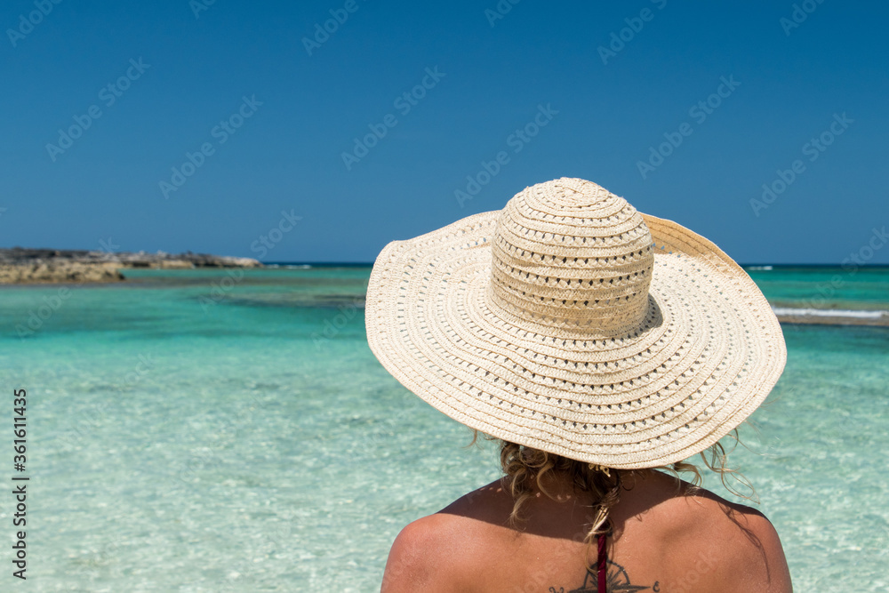 Woman wearing sun hat with tropical water