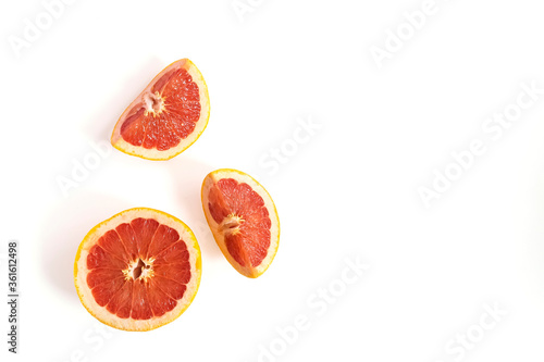 Ripe red whole and sliced grapefruit on white background. Minimal fruit concept.
