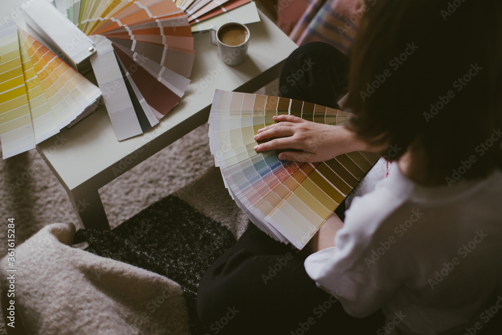 Φωτογραφία Woman choosing paint color from swatches and palette for house renovation and repair