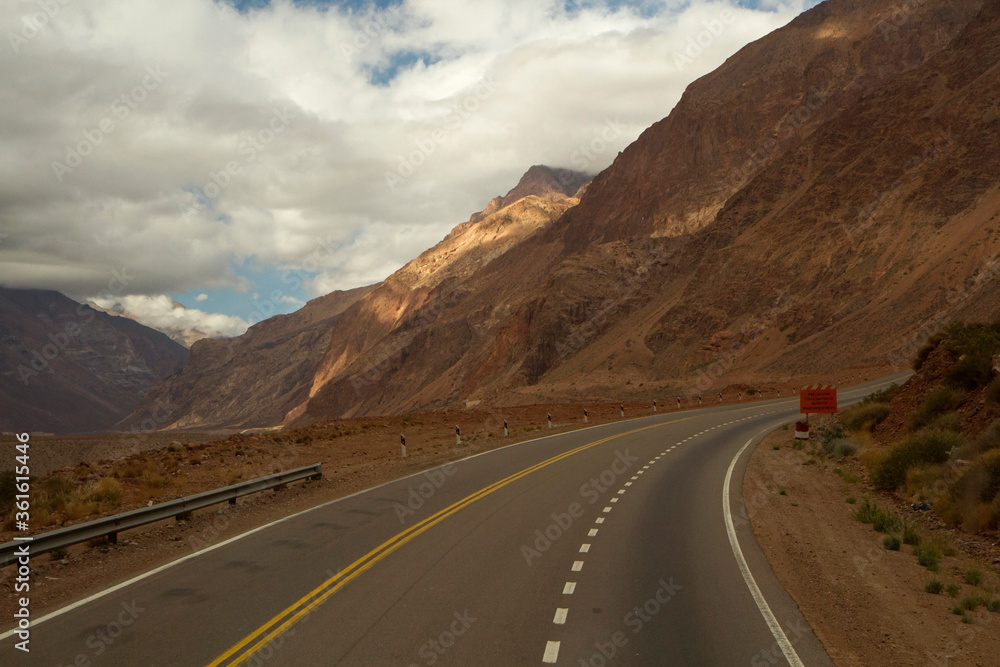 Travel. Driving along the curved asphalt route 40 in the yellow mountains, on the way to mount Aconcagua.
