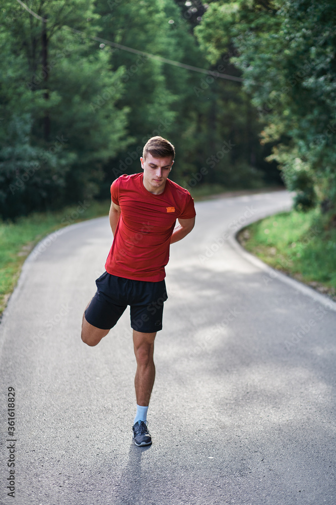 Young man running alone on an empty road Young man running alone on an empty road