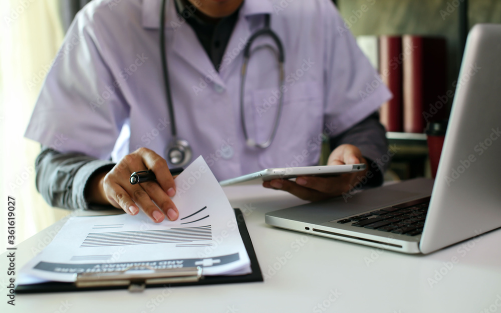 Fototapeta premium Medical technology concept The doctor works with mobile phones, headphones and tablets. Digital laptop Pressing the calculator in the modern office at the hospital in the morning