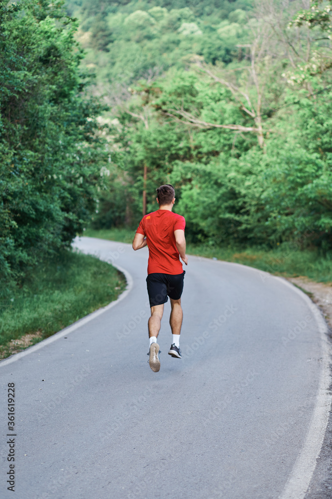 Young man running alone on an empty road Young man running alone on an empty road