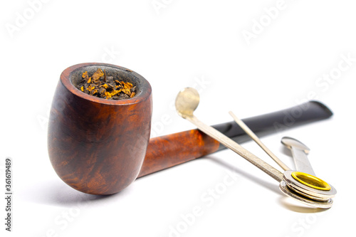 Smoking briar pipe with czech tool on a white background