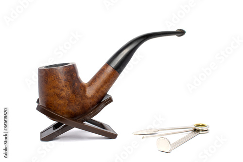 Smoking briar pipe with czech tool on a white background