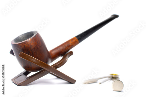 Smoking briar pipe with a czech tool on a white background