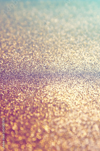 Light Gold glitter texture sparkling paper background. Abstract twinkled glittering background with bokeh, defocused lights for Christmas holiday, banner, wedding invitation and greeting cards.