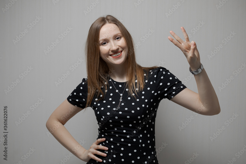 The beautiful emotional girl portrait. The woman shows three fingers on her hand. The beautiful emotional girl portrait. The woman shows three fingers on her hand.