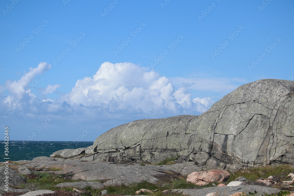 Rolling granite hill on Swedish coast with ocean background