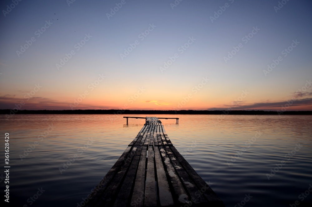 orange sunset  on a lake and wooden pier