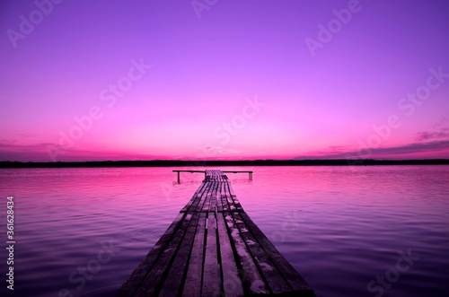 purple sky and pier on a lake at sunset