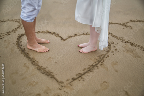 newlyweds on the beach in a painted heart