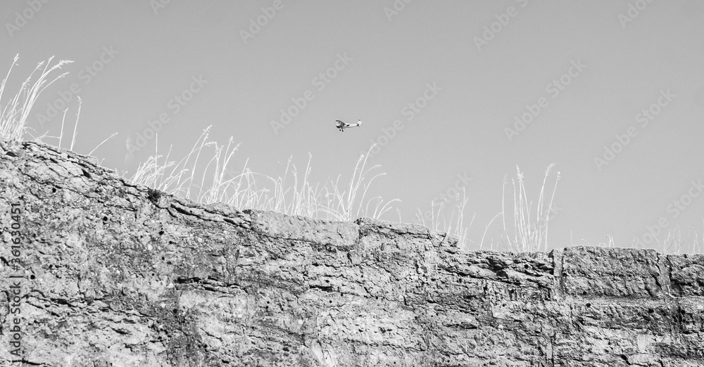Obraz premium An airplane fly above the wall of the medieval fortress Koporye
