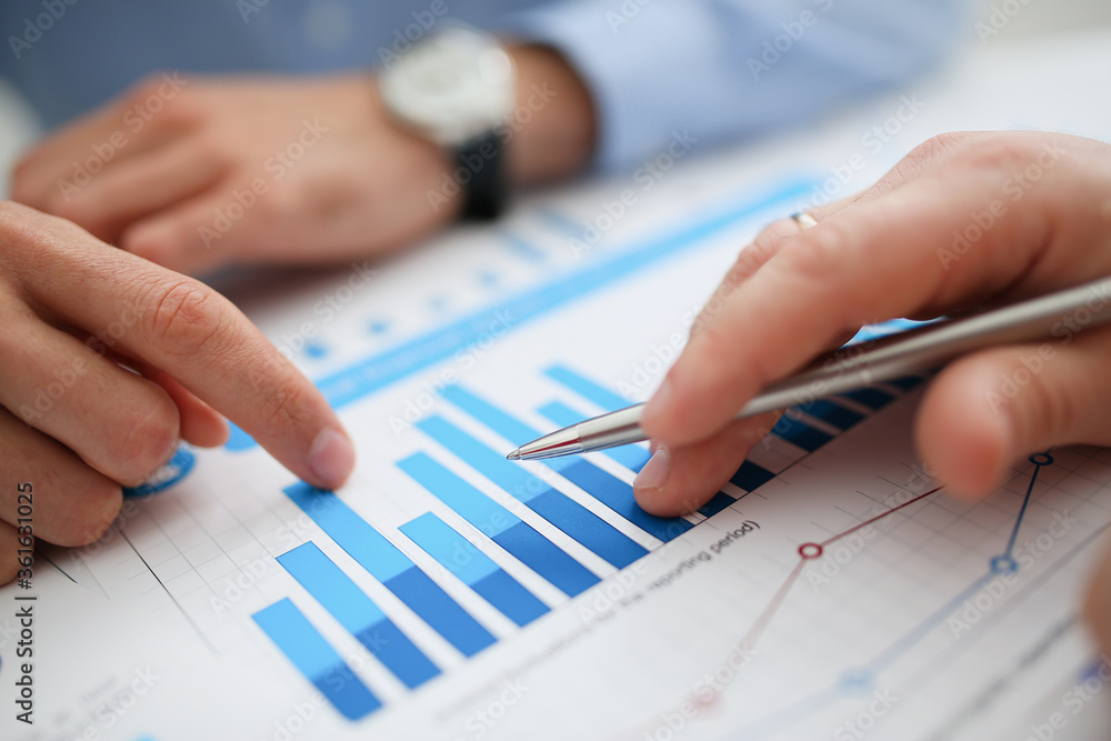 Group of people deliberate on problem with infographics closeup. White collar check money papers stock exchange market earnings list partnership agreement discussion concept Group of people deliberate on problem with infographics closeup. White collar check money papers stock exchange market earnings list partnership agreement discussion concept