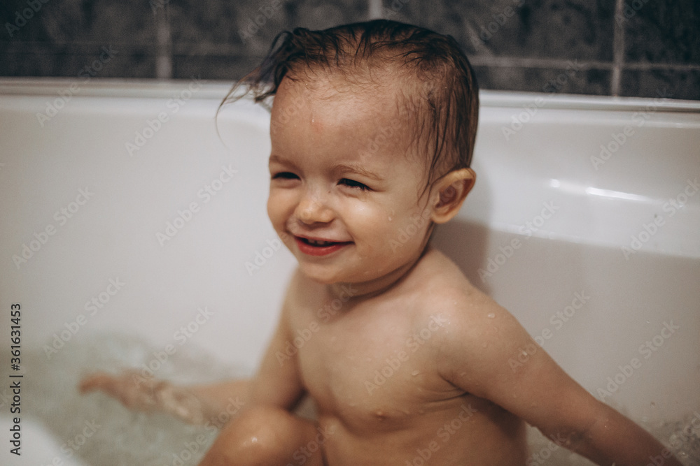 selective focus, noise effect: family is washing and bathing the baby in the bathroom, child girl have fun, she is happy and smiling, likes to enjoy water selective focus, noise effect: family is washing and bathing the baby in the bathroom, child girl have fun, she is happy and smiling, likes to enjoy water