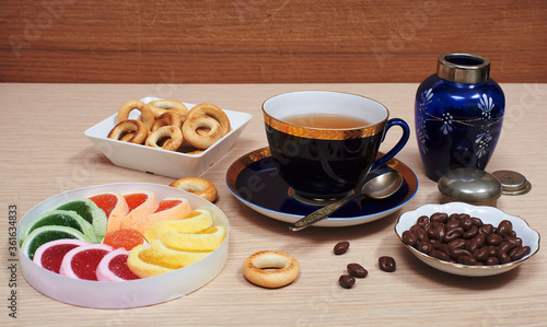 Cup of tea, fruit jelly, chocolate covered raisins, ring-shaped cracknel