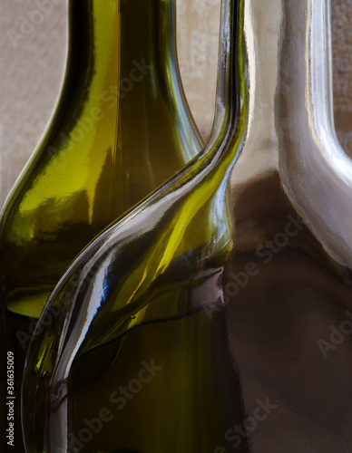 Green and transparent bottles backlit close-up vertical