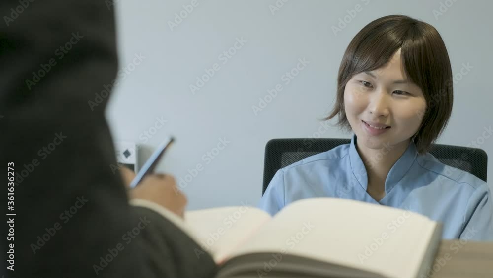 Dental assistant speaking with patient at front desk Dental assistant speaking with patient at front desk