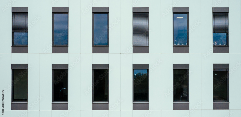 Large office windows on a concrete white wall. View from outside