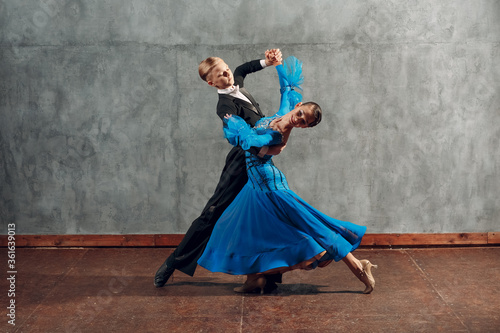 Obraz na plátně Young couple dance slow waltz in ballroom.